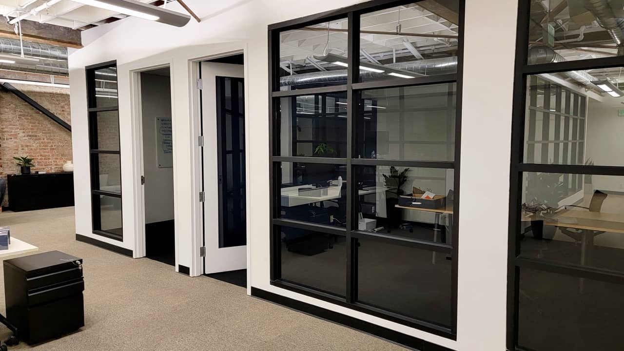 Black-framed steel-and-glass office partitions with grid mullions, Bay Area workspace