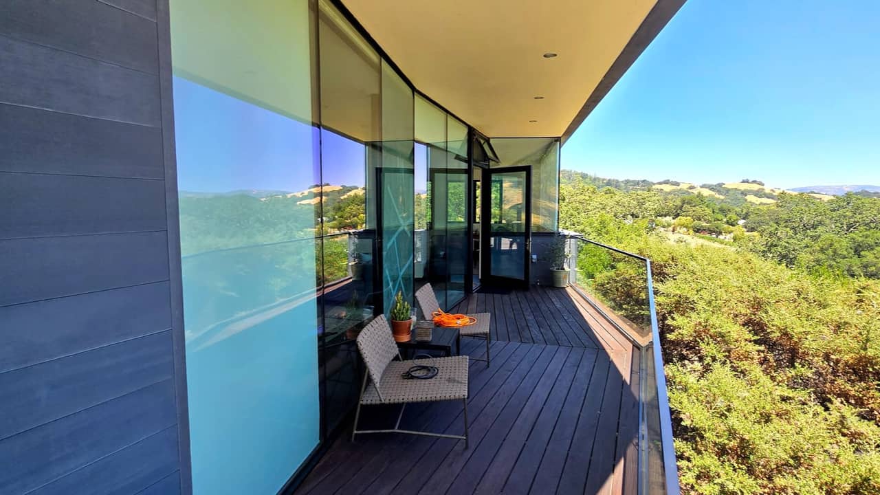 Curved corner glass wall wrapping a hillside deck, Bay Area home